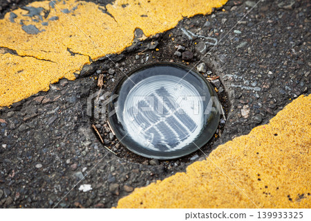 Solar Powered LED Road Stud Beside Yellow Marking Solar Powered LED Road Stud Beside Yellow Marking 139933325