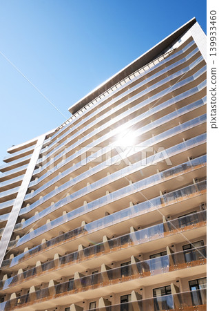 Modern high-rise residential buildings with glass facades against a clear blue sky. Modern high-rise residential buildings with glass facades against a clear blue sky. 139933460