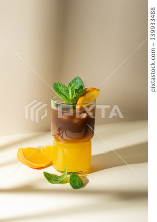 Cold bumble coffee with orange juice and ice on yellow background Cold bumble coffee with orange juice and ice on yellow background 139933488