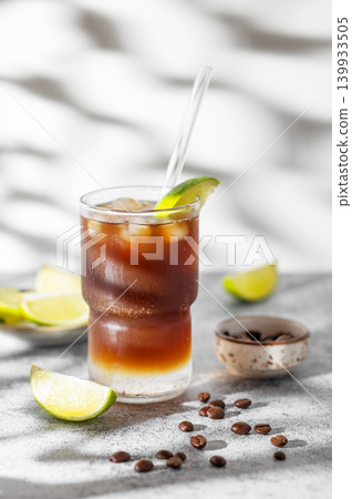 Cold Coffee Tonic Drink With Lime and Ice on light background with shadows 139933505