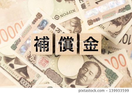 A block with "Compensation" written on it and lots of 10,000 yen bills. 139933599