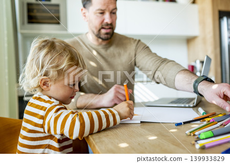 Remote working dad taking care of ill child during home office day. Remote working dad taking care of ill child during home office day. 139933829