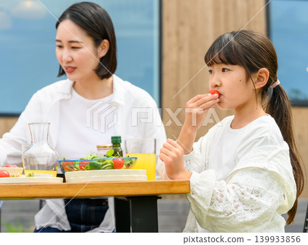 A mother and daughter enjoying a meal outdoors A mother and daughter enjoying a meal outdoors 139933856