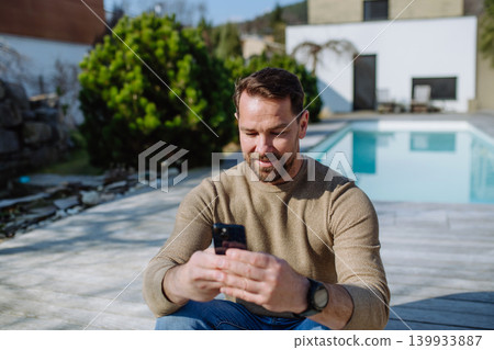 Man enjoying warm spring sunlight on face while standing outside. 139933887