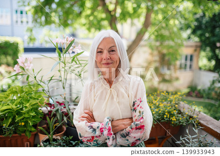 Portrait of beautiful senior woman standing on balcony. Portrait of beautiful senior woman standing on balcony. 139933943