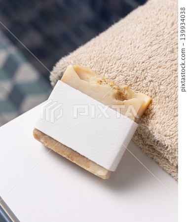 Beige soap with blank paper label mockup with beige towel in blue bathroom. Unbranded packaging Beige soap with blank paper label mockup with beige towel in blue bathroom. Unbranded packaging 139934038