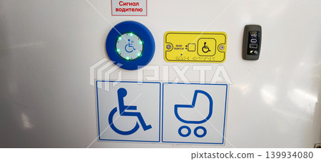 Accessibility control panel featuring symbols for wheelchair users and strollers, illuminated button, and key fob for public transport entry 139934080