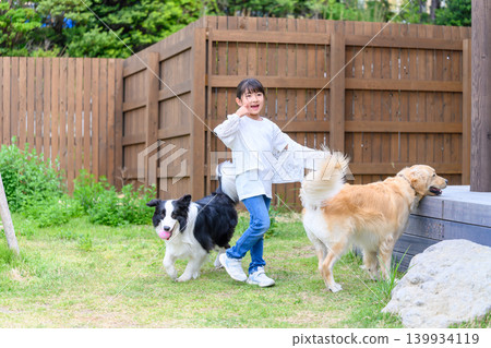 A girl playing with a dog in the garden A girl playing with a dog in the garden 139934119