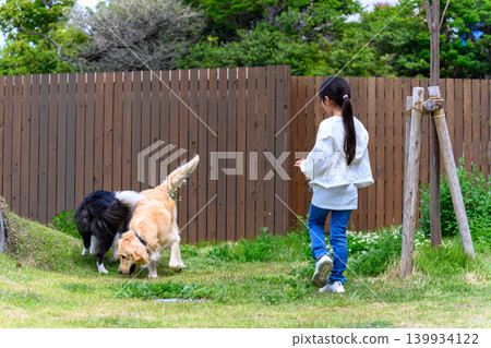A girl playing with a dog in the garden A girl playing with a dog in the garden 139934122