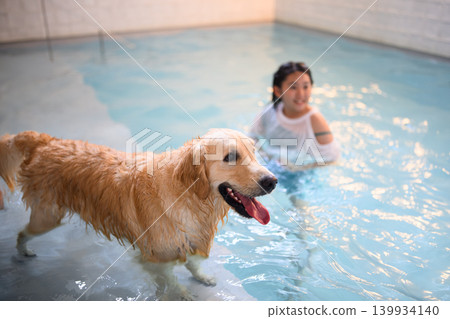 Woman playing in a pool with her dog Woman playing in a pool with her dog 139934140