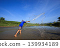 Fisherman Casting a Net in Shallow River Under Clear Blue Sky During Daytime Outdoors 139934189