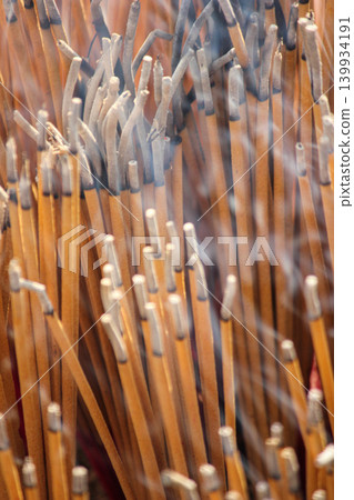 Close-Up Of Burned Incense Sticks With Smoke Rising In A Temple Ritual Offering Close-Up Of Burned Incense Sticks With Smoke Rising In A Temple Ritual Offering 139934191