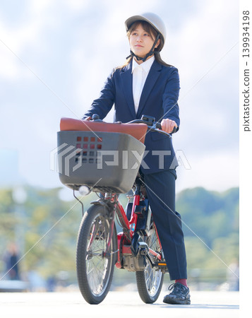 一位身穿職業套裝的日本女商人騎自行車上下班。 139934198