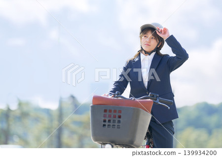A Japanese businesswoman in a suit commuting by bicycle. A Japanese businesswoman in a suit commuting by bicycle. 139934200