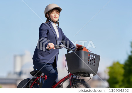 藍天下，一位面帶微笑的女子騎著電動自行車。 139934202