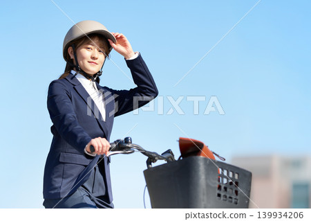 A female office worker riding a bicycle under the blue sky A female office worker riding a bicycle under the blue sky 139934206