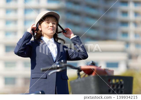 戴著自行車頭盔的女商人。 139934215