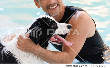A man enjoying himself with his dog in the water. A man enjoying himself with his dog in the water. 139934228
