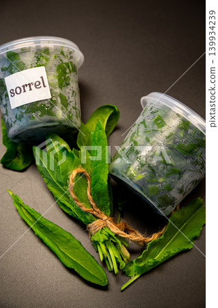 Natural organic sorrel in container with rustic dark backdrop 139934239