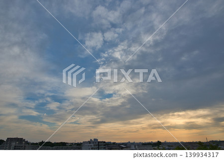 The sky is dyed orange; the sunrise spreads over the residential area; sunrise; morning in a residential area; early morning; sunrise; morning sun; sun. 139934317