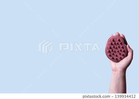 Scalp massage with exfoliating brush on blue background. Illustration of washing routine. Concept of scalp care, trichology, natural cosmetics, and home wellness therapy Scalp massage with exfoliating brush on blue background. Illustration of washing routine. Concept of scalp care, trichology, natural cosmetics, and home wellness therapy 139934412