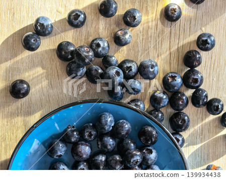 Fresh Blueberries Scattered Near Blue Bowl Fresh Blueberries Scattered Near Blue Bowl 139934438