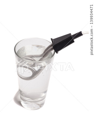 Immersion electric water heater in a glass of water isolated on white background Immersion electric water heater in a glass of water isolated on white background 139934471