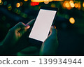 Night scene with glowing hands gripping phone 139934944
