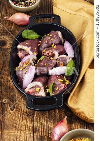 Raw turkey hearts with onion and herbs in baking dish Raw turkey hearts with onion and herbs in baking dish 139935002