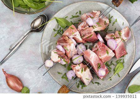 Raw pork skewers with onion and herbs on plate Raw pork skewers with onion and herbs on plate 139935011