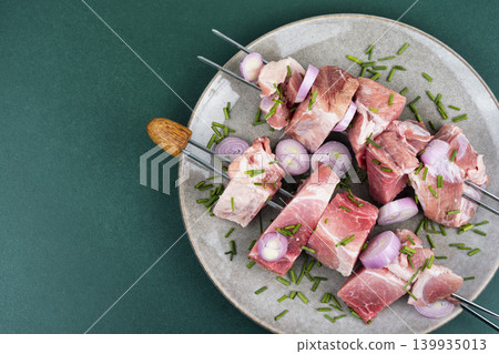 Uncooked pork kebabs with onion on skewers Uncooked pork kebabs with onion on skewers 139935013