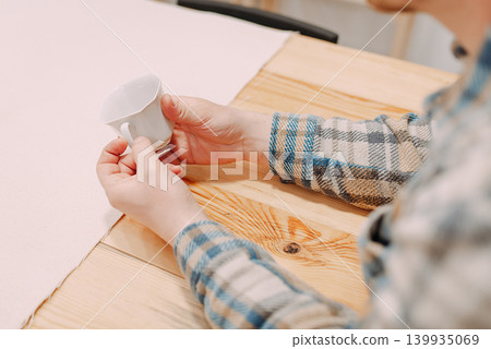 Man holding handmade ceramic cup at painting workshop Man holding handmade ceramic cup at painting workshop 139935069
