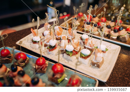 Assorted canapes and finger foods on trays for a holiday buffet Assorted canapes and finger foods on trays for a holiday buffet 139935087