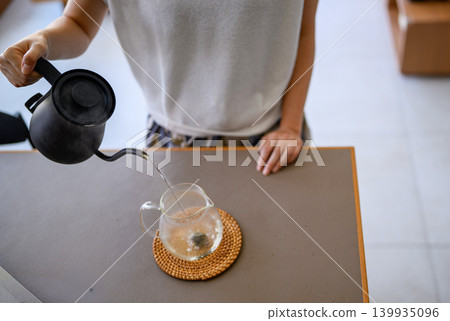 Coffee pot pouring into a pitcher Coffee pot pouring into a pitcher 139935096