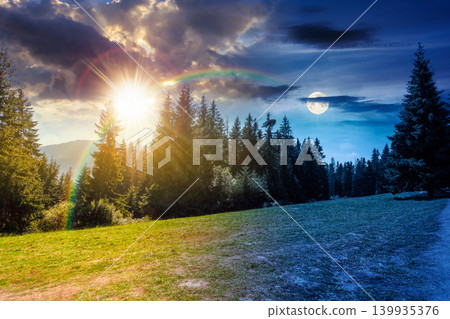 landscape with coniferous forest in summer. day meet night. scenic view of mountain landscape in poland. sun and moon in harmony over spruce trees on a grassy alpine meadow. epic sky above the ridge landscape with coniferous forest in summer. day meet night. scenic view of mountain landscape in poland. sun and moon in harmony over spruce trees on a grassy alpine meadow. epic sky above the ridge 139935376