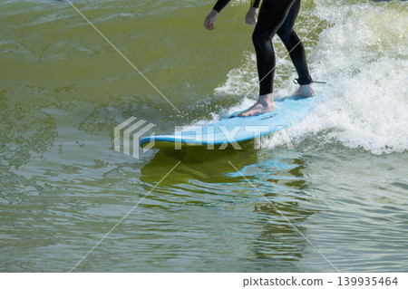 Action shot of a surfer riding an wave on a bodyboard with splashing white water on a sunny day. Action shot of a surfer riding an wave on a bodyboard with splashing white water on a sunny day. 139935464
