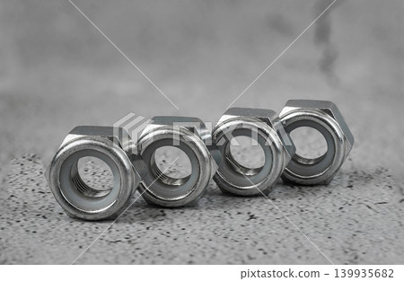 bolts and nuts on a concrete grey background. bolts and nuts on a concrete grey background. 139935682