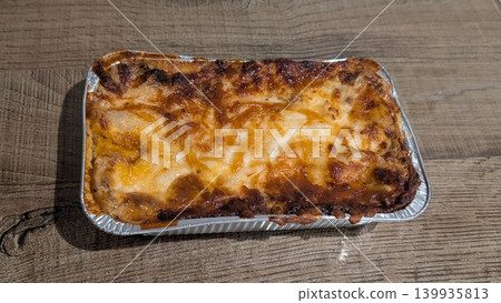 Baked lasagna with cheese in a rectangular aluminum dish Baked lasagna with cheese in a rectangular aluminum dish 139935813