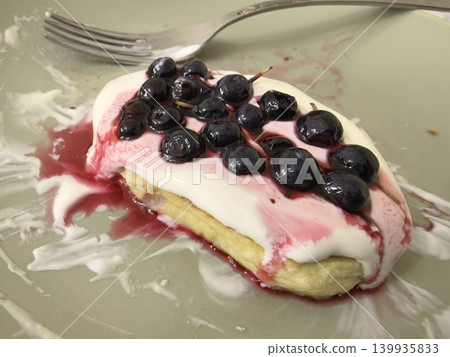 Delicious dessert topped with blueberries and creamy sauce on a plate 139935833