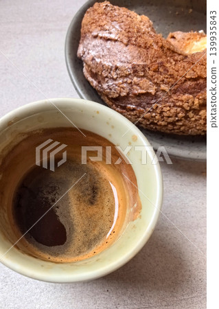 Enjoying rich espresso beside a delightful pastry in a cozy setting Enjoying rich espresso beside a delightful pastry in a cozy setting 139935843