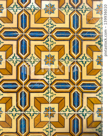 Ornate vintage ceramic wall tiles featuring a complex geometric pattern in ochre yellow cobalt blue and cream hues with intricate floral motifs and a glossy finish capturing Mediterranean charm Ornate vintage ceramic wall tiles featuring a complex geometric pattern in ochre yellow cobalt blue and cream hues with intricate floral motifs and a glossy finish capturing Mediterranean charm 139936010