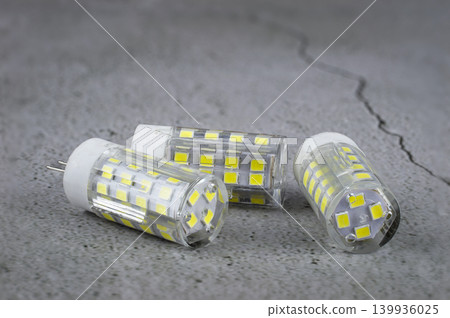 a led light bulb on a concrete background. a led light bulb on a concrete background. 139936025