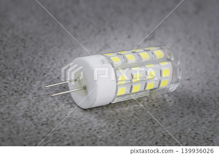 a led light bulb on a concrete background. a led light bulb on a concrete background. 139936026