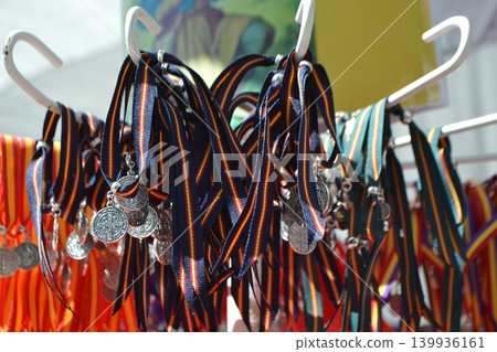Colorful souvenir medals and striped ribbon display at madrid san isidro fair for market stall banner and background Colorful souvenir medals and striped ribbon display at madrid san isidro fair for market stall banner and background 139936161