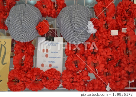 Red carnation accessories and checked hats for san isidro madrid fair stall display and festival decoration Red carnation accessories and checked hats for san isidro madrid fair stall display and festival decoration 139936172