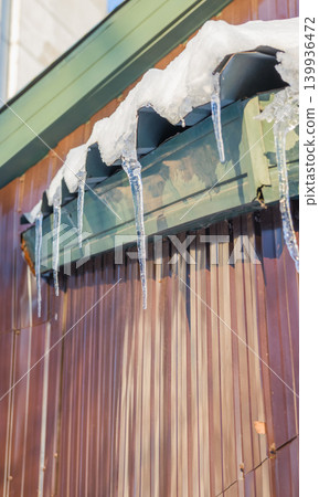 Icicles and Snow on the Roof. Icicles which are hanging down from a roof Icicles and Snow on the Roof. Icicles which are hanging down from a roof 139936472