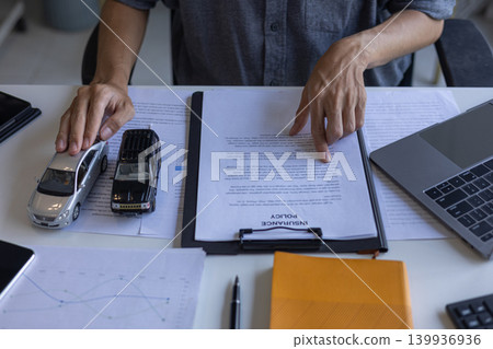 Client Reviewing CarInsurance Policy and Vehicle Finance Documents. Client Reviewing CarInsurance Policy and Vehicle Finance Documents. 139936936