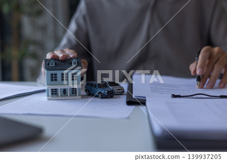 Insurance Advisor Reading Insurance Policy Document on Desk. Bundling Home and Auto Insurance Policy Planning Concept. Insurance Advisor Reading Insurance Policy Document on Desk. Bundling Home and Auto Insurance Policy Planning Concept. 139937205