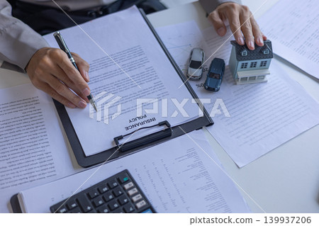 Close-Up of Agent Reading or Explaining Terms of Insurance Policy Contract. Asset Protection and Risk Management Insurance Contract Agreement. Close-Up of Agent Reading or Explaining Terms of Insurance Policy Contract. Asset Protection and Risk Management Insurance Contract Agreement. 139937206