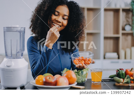 Young nutritionist showing bell peppers during an online video call consulting about healthy eating, sitting at home at a table with vegetables, laptop and measuring tape Young nutritionist showing bell peppers during an online video call consulting about healthy eating, sitting at home at a table with vegetables, laptop and measuring tape 139937242